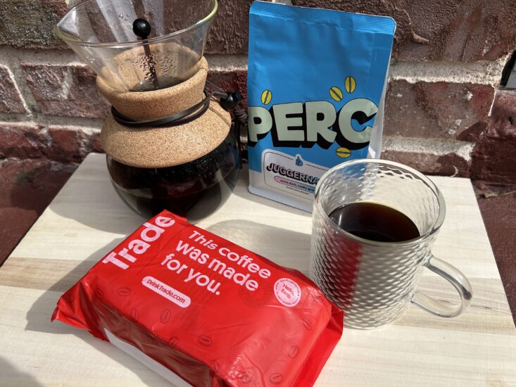 a bag of Trade Coffee in front of a pour over maker and bag of PERC Juggernaut coffee